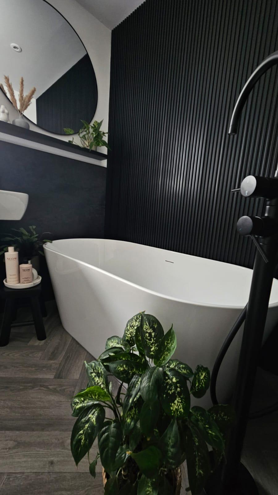 Freestanding bath with a floor-standing tap and fluted wall panel